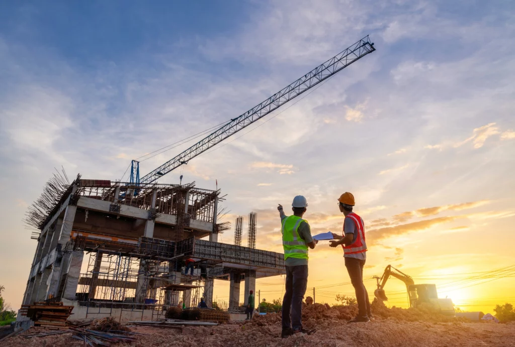 ouvrier sur un chantier devant une maison en construction